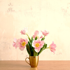 Summer vibes and mood image of bouquet of pink tulips in golden cup on table