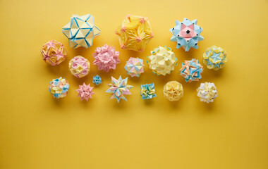 Set of multicolor handmade modular origami balls or Kusudama Isolated on yellow background. Visual...