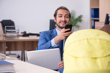 Young male employee looking after new born at workplace