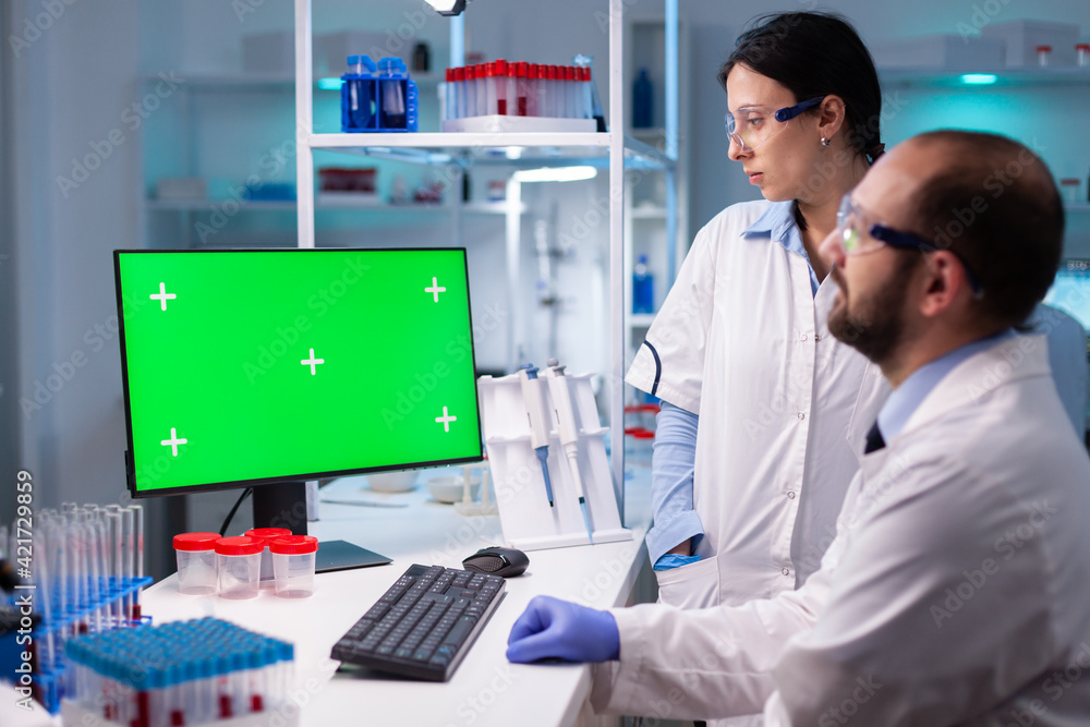 Aufkleber modern medical research laboratory with two scientists using computer with green chroma key screen. 