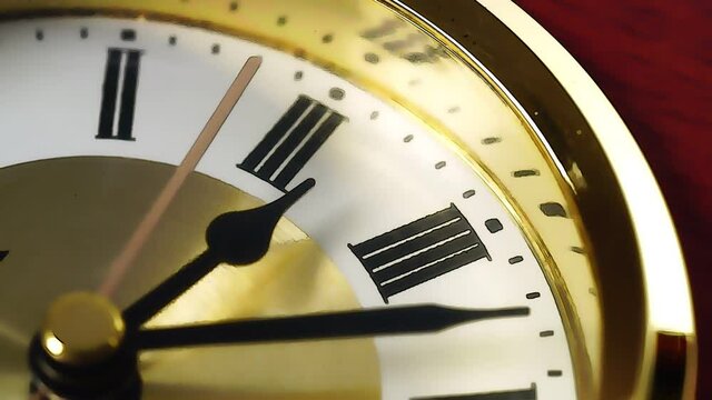 Close-up time of a clock with Roman numerals on the watch face.Gold watch.Time concept.	