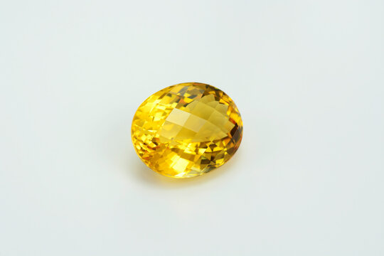 Natural yellow brazilian citrine quartz oval checker faceted gemstone. Unheated, clean, transparent, sparkling, shiny on white backgound. Semiprecious gemstone setting for big solitaire rings.