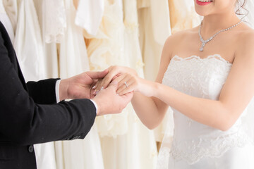 Newlywed or wedding ceremony preparation couple lifestyle concept, Mix race, beautiful Asian girl and Caucasian man eye contact together with love passion, hand hold together with wedding gold rings