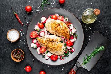 Grilled chicken breast and salad with fresh vegetables, tomatoes and radishes in a plate Chicken meat with salad. Healthy food on stone background