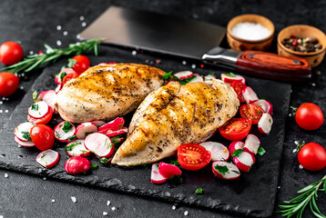 Grilled chicken breast and salad with fresh vegetables, tomatoes and radishes. Chicken meat with salad. Healthy food on stone background