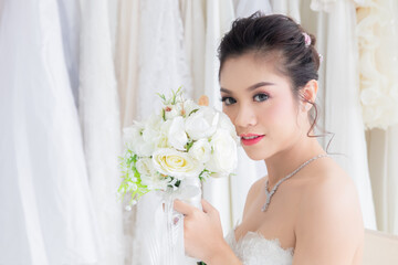 Naklejka premium Asian women seeking foreigner dating concept, beautiful Asian woman in bridal dress hold colorful flowers bouquet close eyes dream to perfect man or rich to create passion relationship or family
