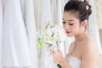 Asian women seeking foreigner dating concept, beautiful Asian woman in bridal dress hold colorful flowers bouquet close eyes dream to perfect man or rich to create passion relationship or family