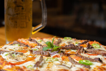 close-up meat pizza and beer