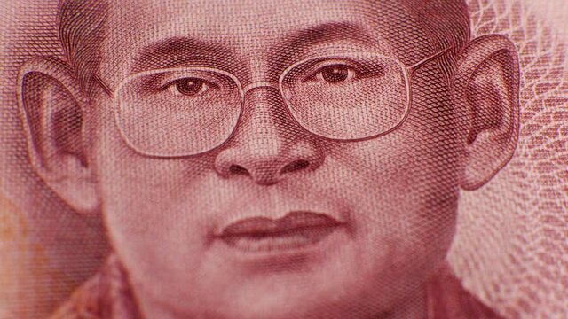 One hundred baht THB banknote. King Bhumibol Great on red paper currency of Thailand. Ninth monarch of Thailand, Chakri dynasty, Rama IX