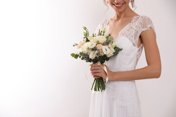 Naklejka premium Young bride with beautiful wedding bouquet on white background, closeup. Space for text