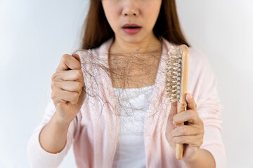 Sad young Asian girl looking at her hair loss with shock isolated on white background. Close up