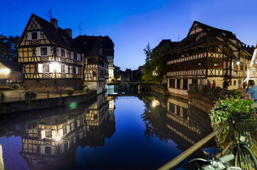 Strasbourg, France, August 2019. In the heart of the old town enchanting glimpse of the canals where the typical historic houses are reflected. People stop and look. Large format photos.