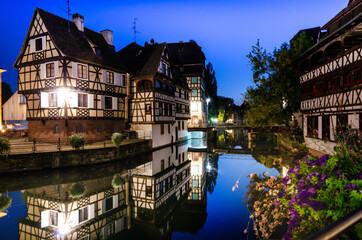 Fototapeta na wymiar Strasbourg, France, August 2019. In the heart of the historic center, an enchanting glimpse of the canals where the typical historic houses are reflected. At the blue hour it has its greatest charm.