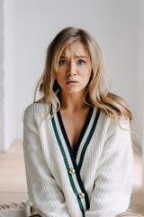 Emotional scared portrait of a young blonde woman, looking at camera.