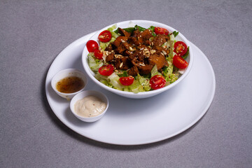 Fresh salad with chicken breast, arugula and tomato. site view