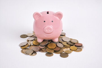 Pink piggy bank on coins white backgrounds.Save money.