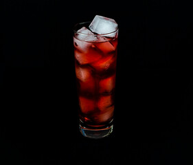 A glass filled with a red cocktail.