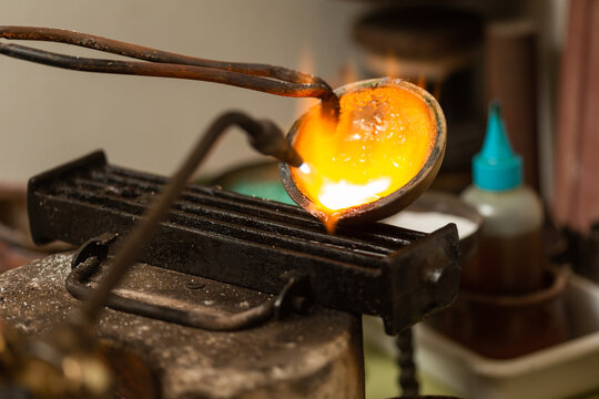 melting with blow torch and foundry of liquid silver from a bowl into a mold