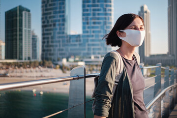 Obraz premium Happy young female traveler in the big city of Dubai, UAE