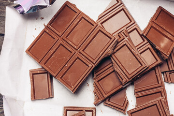 chocolate cubes broken on brown paper on the table