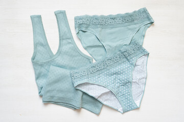Mint color female shirt and panties on the white table background.