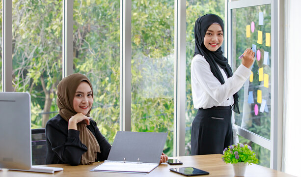 Middle Eastern female colleagues working on project in workplace - Powered by Adobe
