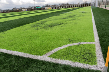 Fototapeta na wymiar Artificial green grass on professional soccer field. An outdoor artificial football field awaiting the players' exit. Inscription on banner in Ukrainian: the second professional football league
