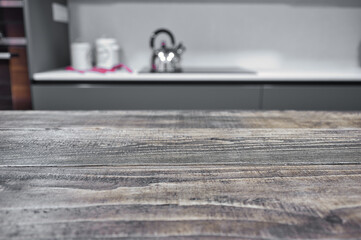 Primer plano de mesa rústica en tonos claros con fondo desenfocado de una cocina de diseño...