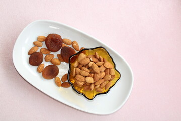 Fruits and nuts in a bowl, almonds and dry apricots