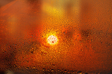 drops on the glass with glowing sunset om background