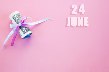 calendar date on pink background with rolled up dollar bills pinned by pink and blue ribbon with copy space. June 24 is the twenty-fourth day of the month