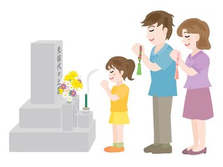 お墓参りをする3人家族