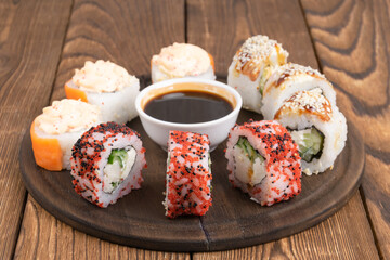 rolls, sushi and sauce on a round plate