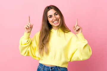 Young woman over isolated pink background pointing up a great idea