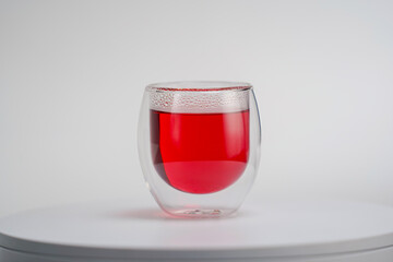 Transparent double wall glass, with red tea, on white background. Easy to use for advertising branding and marketing. Studio light.