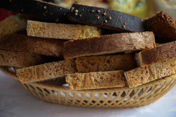 sliced coarse gray bread in a wicker bowl on the table