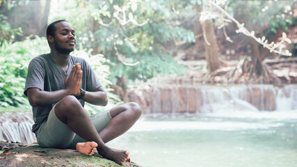 African man meditate spiritual peaceful praying and wishing in green nature