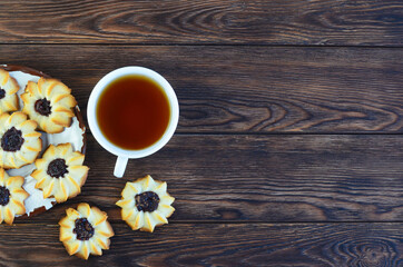 homemade shortbread cookies kurabye and a cup of tea on a textured wooden table top view