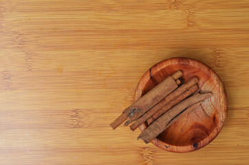 cinnamon in a wooden bowl on a wooden tray. close up with selective focus