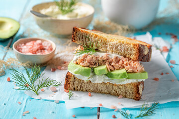Tasty sandwich with avocado, salmon and dill for healthy breakfast.
