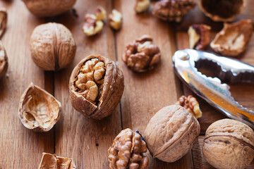 broken walnuts on a wooden background. split nuts near the nutcracker
