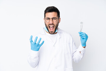 Dentist man holding tools isolated on white background unhappy and frustrated with something