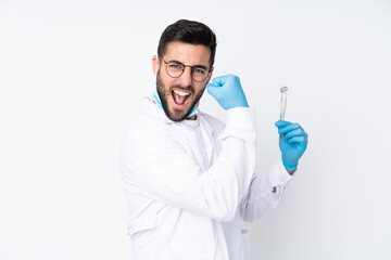 Dentist man holding tools isolated on white background making strong gesture