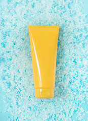 yellow tube of sunscreen on sea blue salt