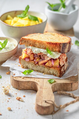 Tasty sandwich with chicken, fruits, onion and herbs.