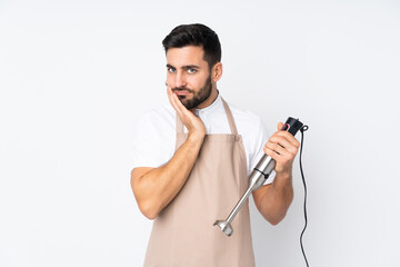 Man using hand blender isolated on white background unhappy and frustrated