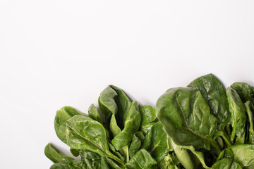 Pile of fresh green spinach leaves on white background. Close up. empty space