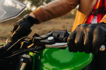 Hands of a motorcyclist on the road having fun driving on the empty road on a motorcycle trip