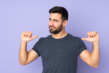 Fototapeta premium Caucasian handsome man proud and self-satisfied over isolated purple background