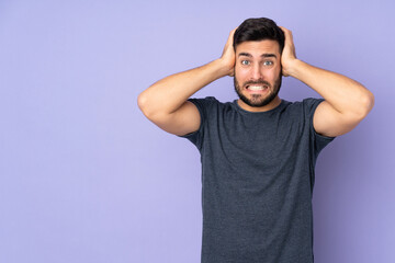 Caucasian handsome man doing nervous gesture over isolated purple background
